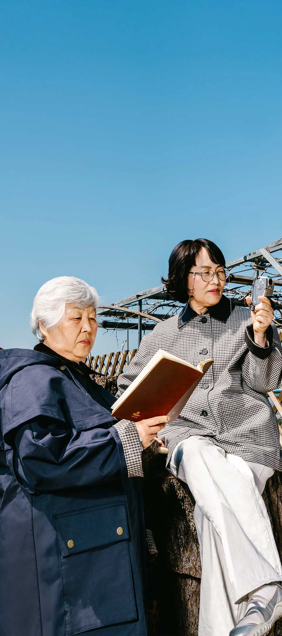 노트를 든 고의숙과 캠코더를 든 조순희가 수사 자료를 검토하듯 열중하는 표정으로 각자 손에 든 물건을 살피는 사진. 나란히 자리한 두 사람의 몸은 오른쪽으로 향해 있다.